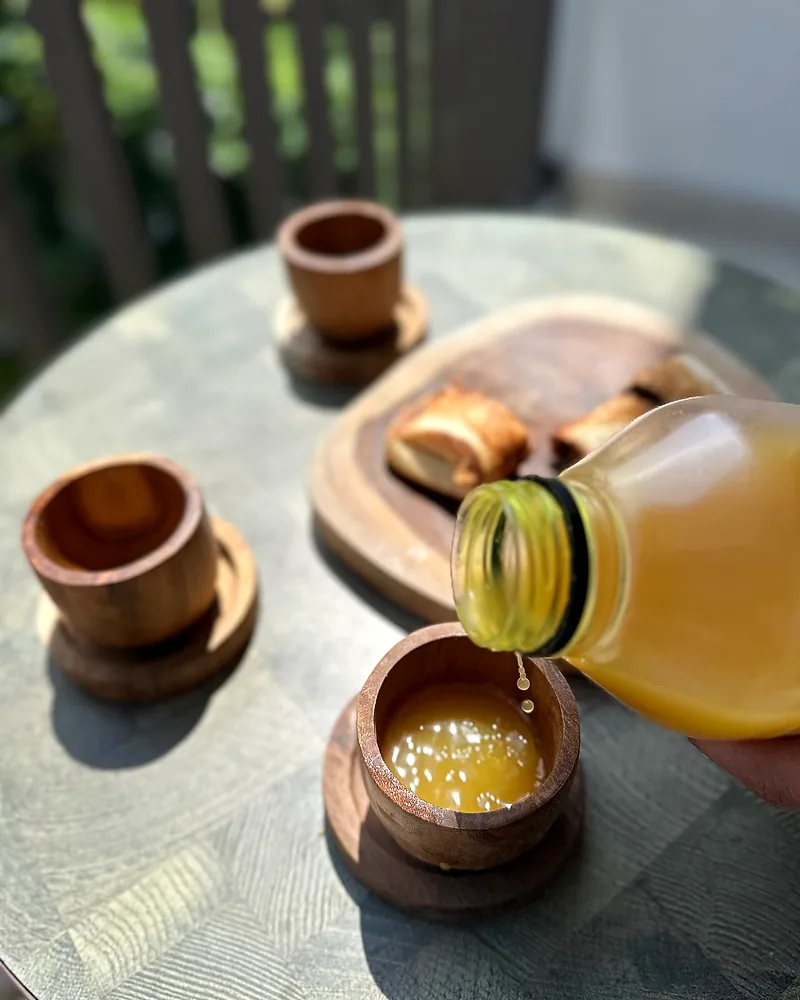 Segelas jamu beras kencur di atas meja kayu
