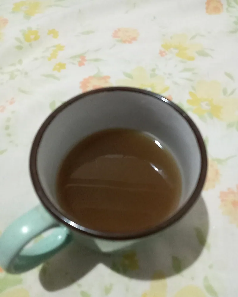 Mug berisi seduhan rempah hangat berwarna gelap